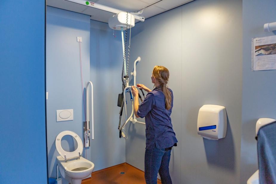 Verzorgende IG aan het werk met tillift